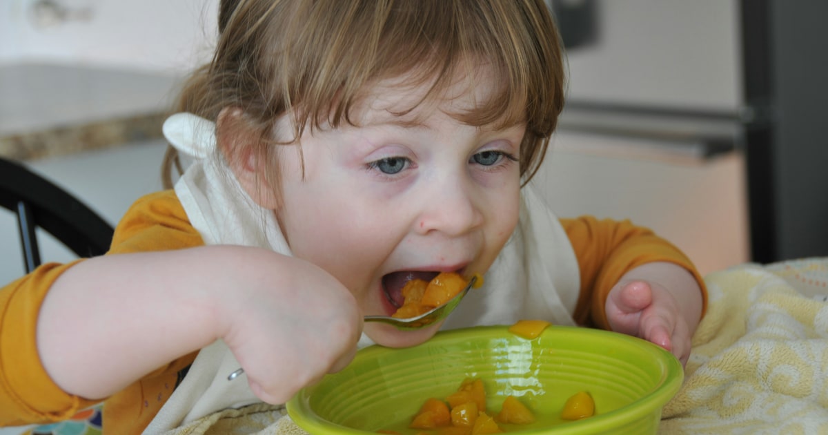 Baby food pouches and jars with halal labels being checked by a parent in a UK supermarket
