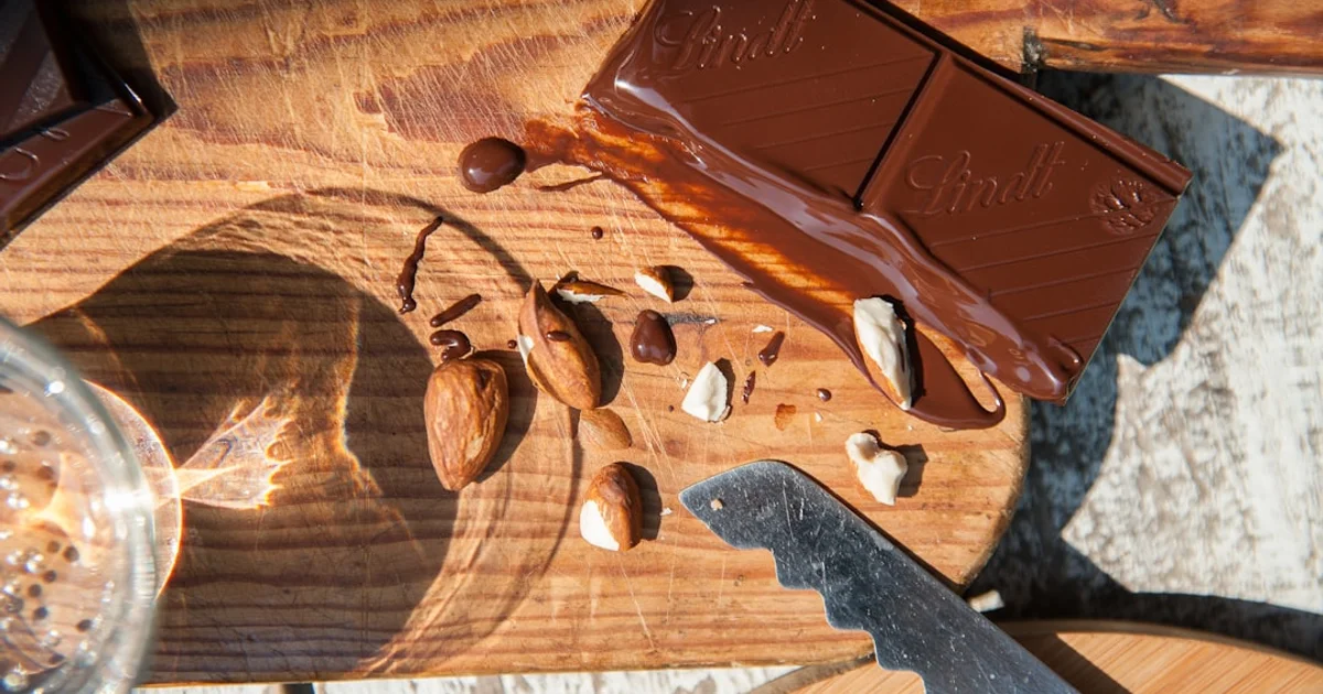 Blocks of dark and milk chocolate with almonds on a wooden board, New Zealand halal chocolate guide