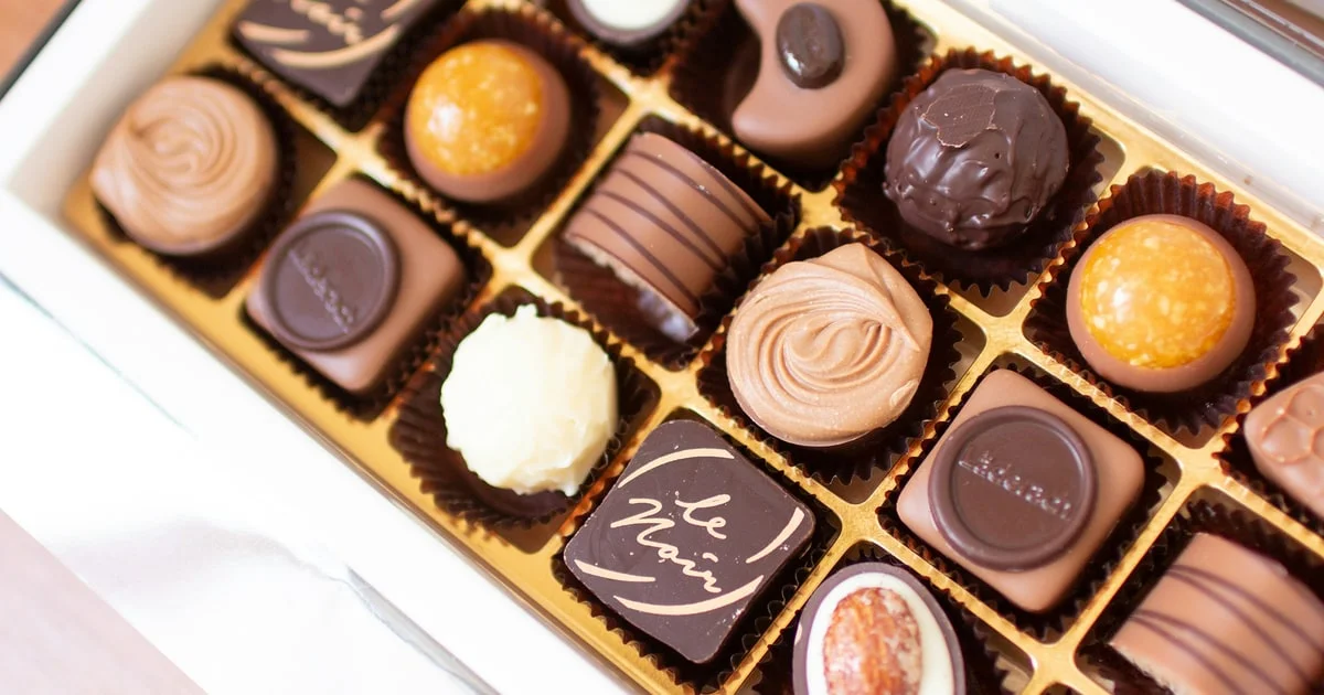 Swiss chocolate bars and pralines arranged on a wooden surface