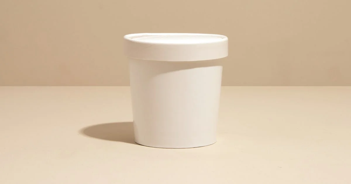 Scoops of ice cream in a tub with a scoop beside it