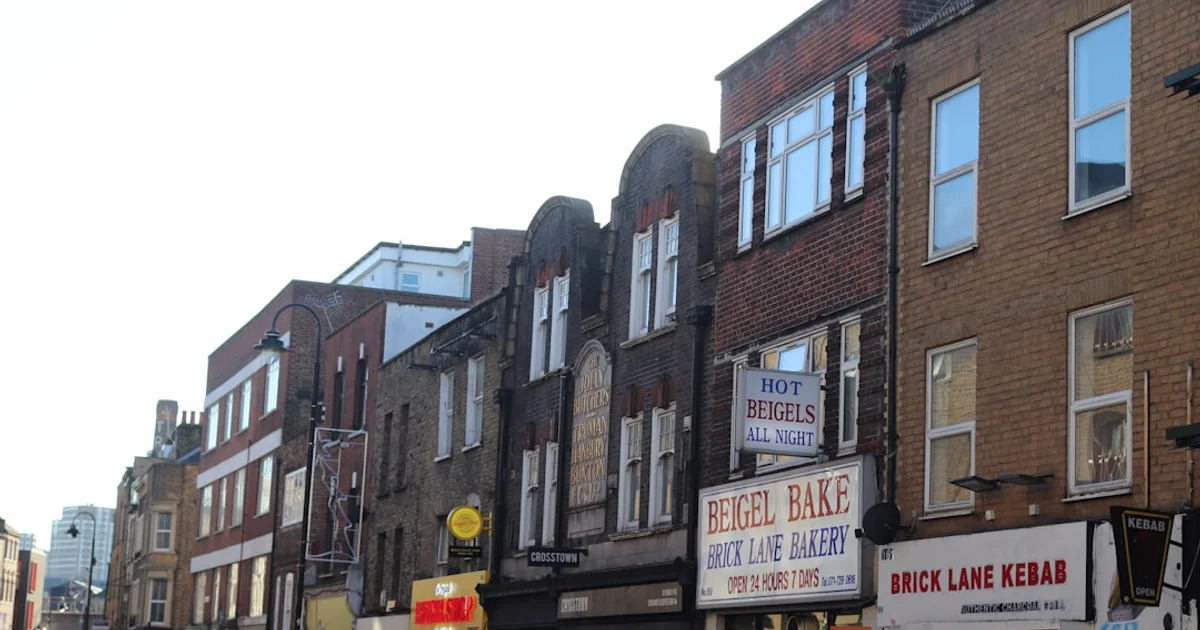 Busy East London high street with independent food shops and market stalls