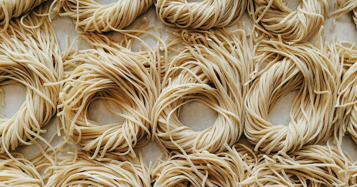 Nests of uncooked egg noodles arranged in rows