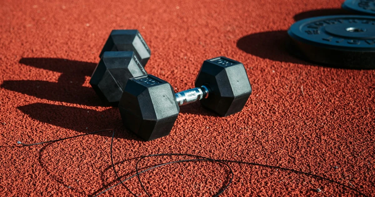 Protein shaker and supplement tubs on a gym bench