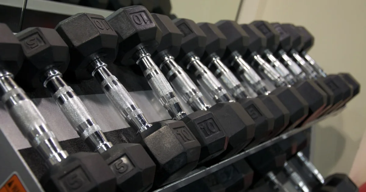Protein powder tubs and shaker bottle on a gym bench