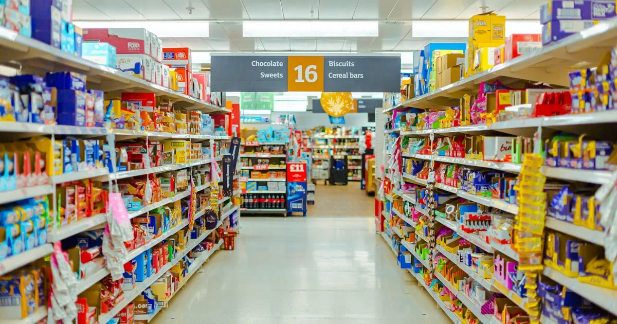 Supermarket aisle of chocolate, sweets and biscuits where additive numbers appear on every pack