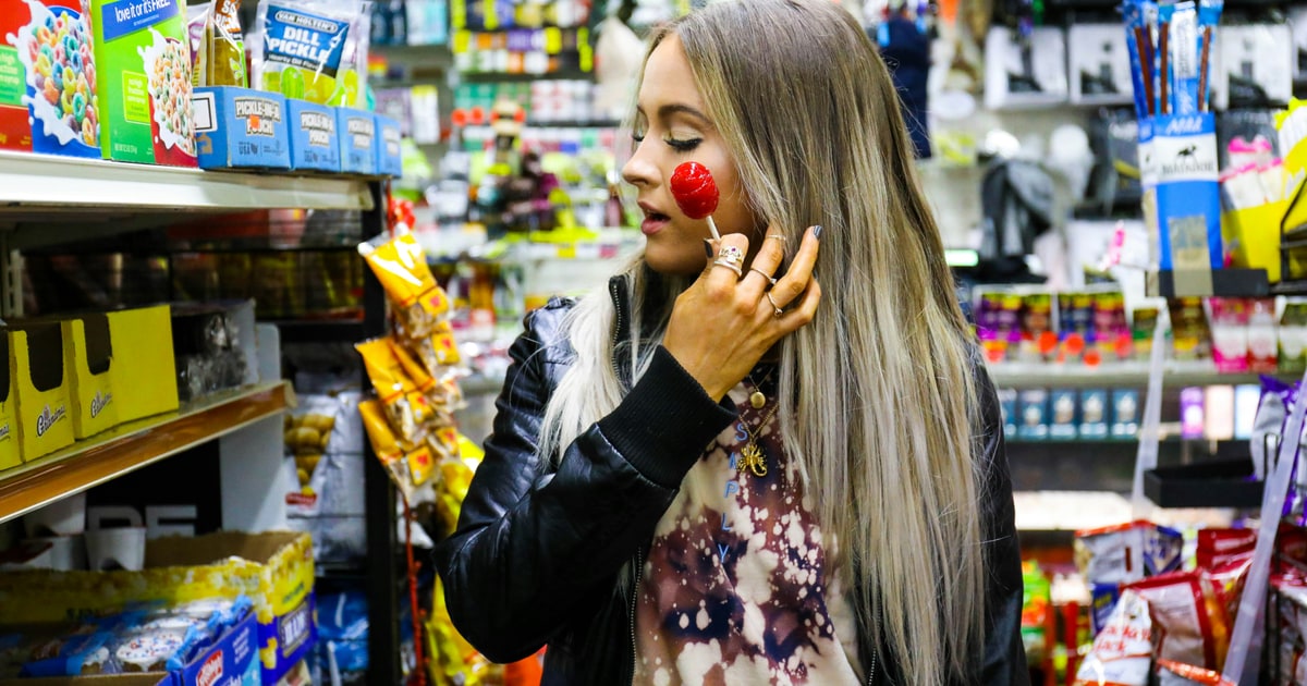 Person using a phone in a grocery store aisle — manual and voice search each have their ideal use case